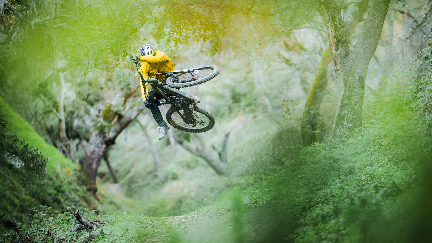 Mountain bike rider jumping in a forest trail